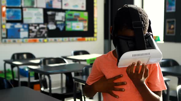 Schoolboy using virtual reality headset in classroom 4k