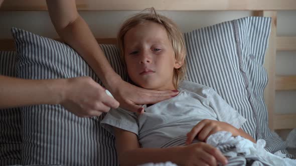 Sick Little Boy in a Bed Mother Rubs Boy's Chest with Ointment with Essential Oils Baby Flu