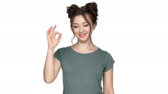 Portrait of Young Woman with Double Buns Hairstyle Smiling on Camera and Gesturing Altight Symbol