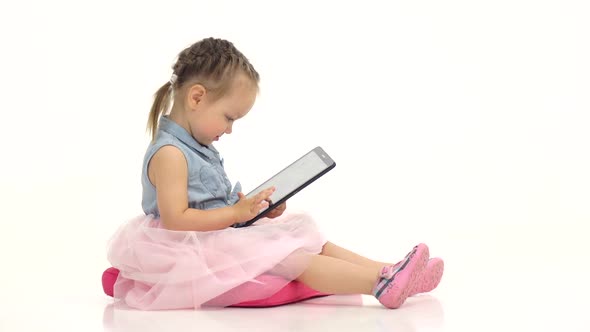 Little Girl in Her Hands Is Holding Aipad. White Background