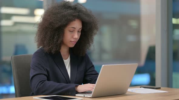 African Businesswoman with Laptop Smiling at Camera