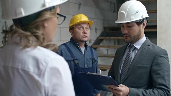 Business people Discussing Work in Unfinished Building alt