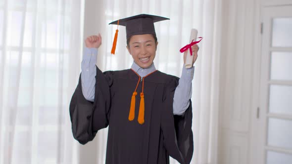 Asian graduate in cap and gown smile and holding certificate or diploma proud of yourself