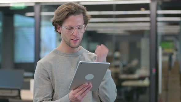 Portrait of Young Businessman Celebrating Success on Tablet