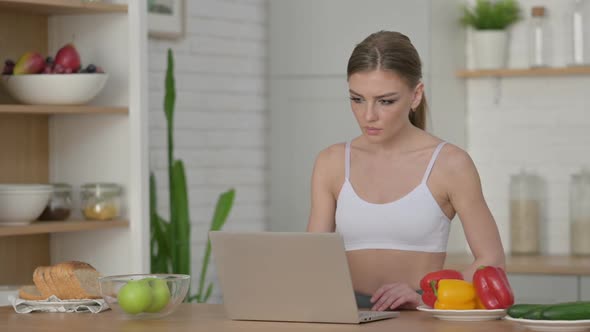 Athletic Woman Working on Laptop in Kitchen