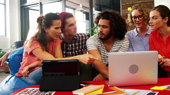 Business executives discussing over laptop in meeting