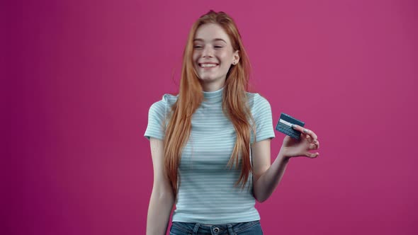 Happy Redhead Teenager with Card in Hand Recommends Online Transactions in Blue Casual Tshirt