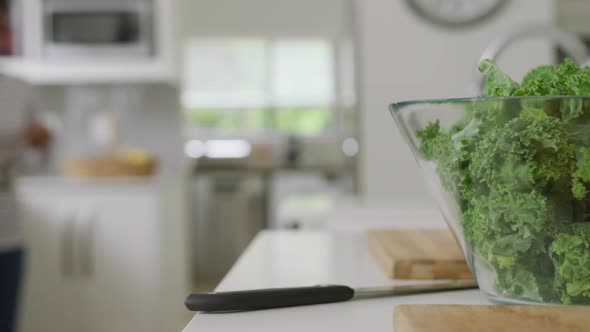 Video of bowl with salad and utensils lying on countertop in kitchen