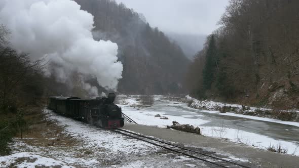 Train stopping near a frozen river