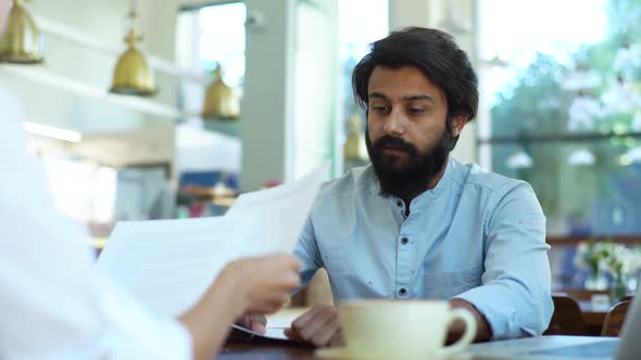 Medium Shot of Serious Businessman and Businesswoman Having Business Negotiations Checking Paper