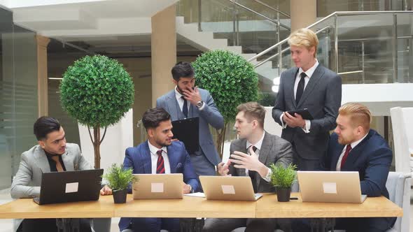 Smart and Young Men Conduct Negotiations in Business Office.