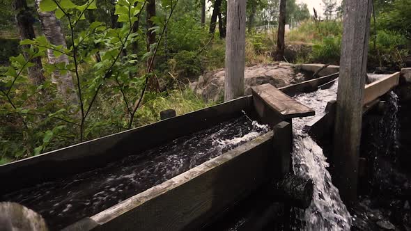 Water going through old wooden river mill in slow motion bypassed