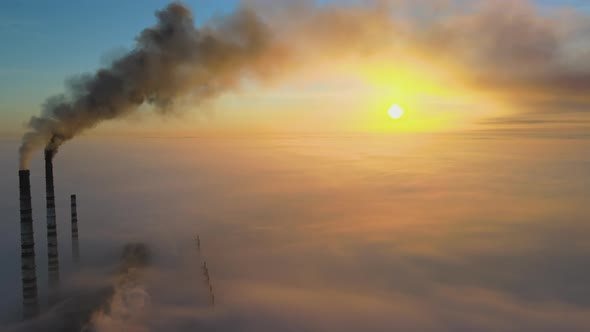 Aerial View of Coal Power Plant High Pipes with Black Smoke Moving Up Polluting Atmosphere at Sunset