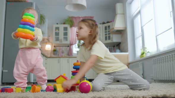 Two Sisters Girls Children Play Toys In The Room At Home