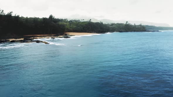 Drone shooting ocean, beach, tropical forest on a rainy day at Kauai, Hawaii, USA