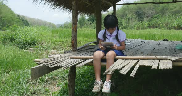 Little Girl Using Tablet In Cottage