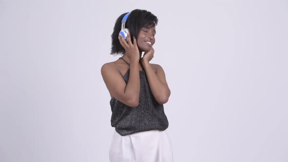 Happy Young Beautiful African Woman Listening To Music and Looking Shocked