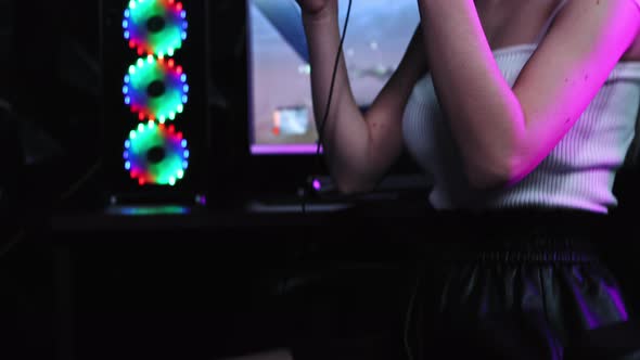 Blonde and Pretty Gamer Girl Puts on Big Headphones and Looking in the Camera  Neon Lighting