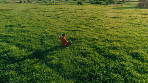 Low Altitude Radial Flight Over Sport Yoga Man at Perfect Green Grass