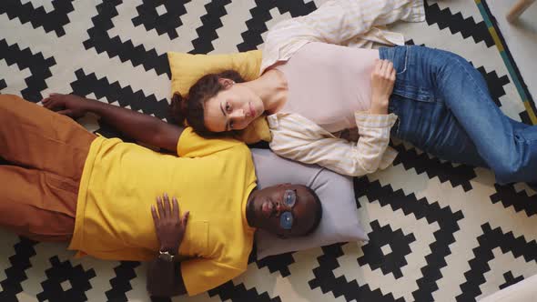 Beautiful Multiethnic Couple Lying on Floor at Home