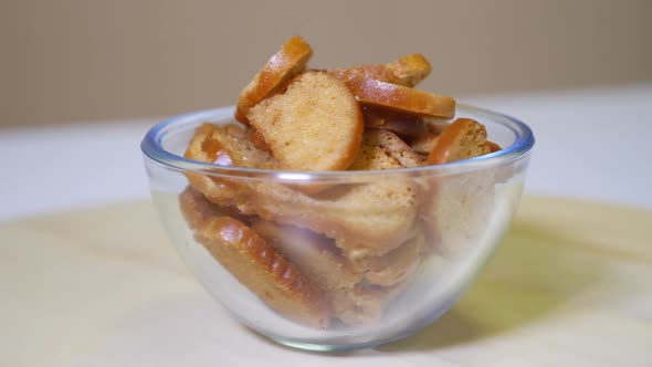 Tasty bread crackers in a glass bowl on a rotating wooden platform