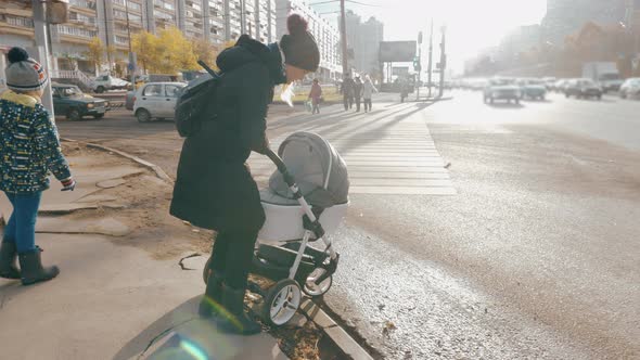 Mother having problems with pushing pram in the street