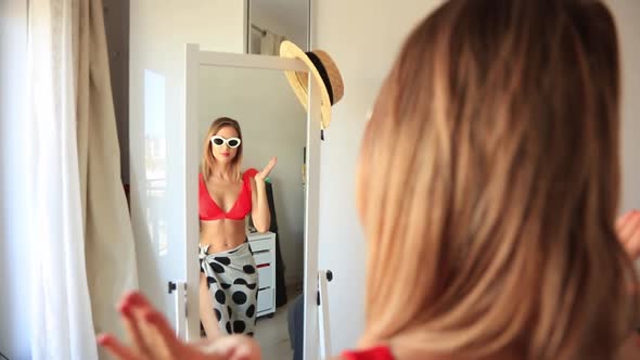 Young girl dressing up near a mirror.