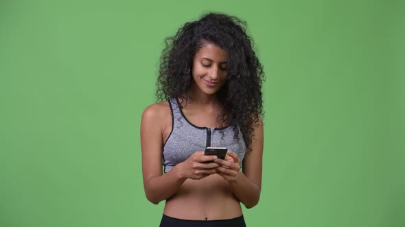 Young Beautiful Hispanic Woman with Gym Clothes Using Phone