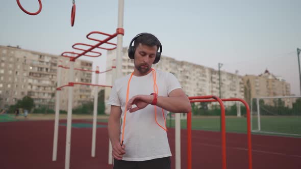 Tired Caucasian Male Relaxing After Training at Outdoor Training Ground