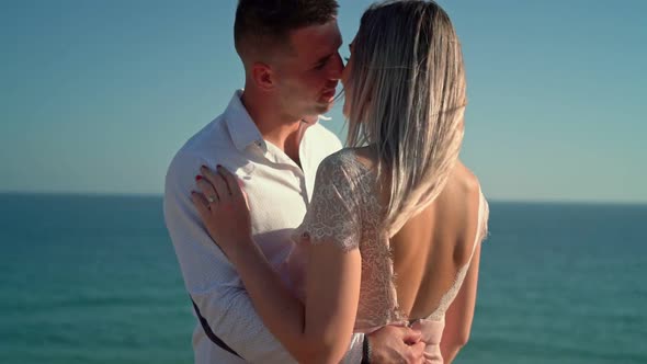 A Young Couple at a Romantic Meeting on the Seashore Kissing in Slow Motion