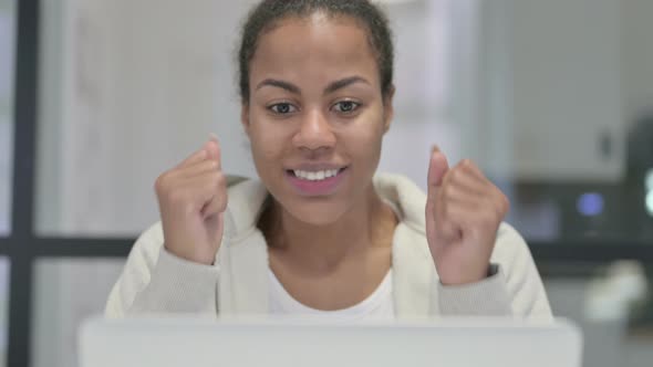 Close Up of African Woman Celebrating Success on Laptop