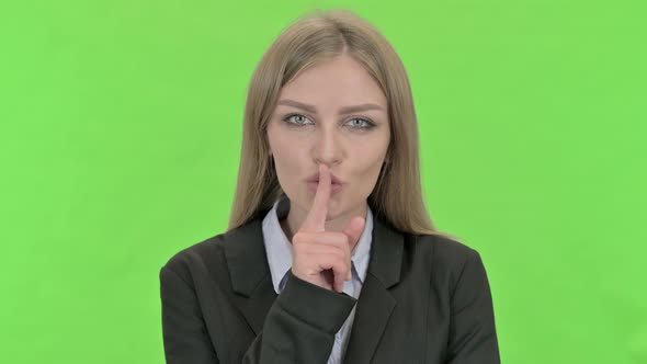 Young Businesswoman Finger on Lips Against Chroma Key