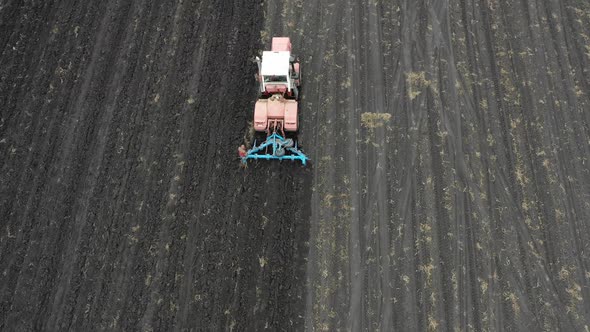 Aerial View: Tractor with a Plow Cultivating the Field. Agricultural Concept