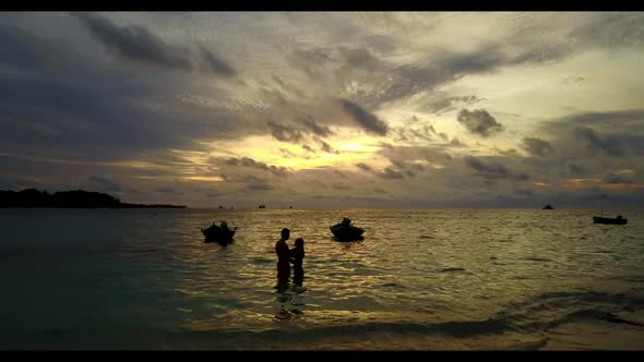 Man and woman engaged on relaxing bay beach voyage by turquoise sea and white sandy background of th