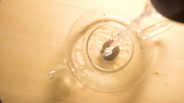 Pouring Hot Water in Teapot with Green Tea