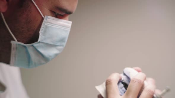 Man in mask with prosthesis in articulator in lab