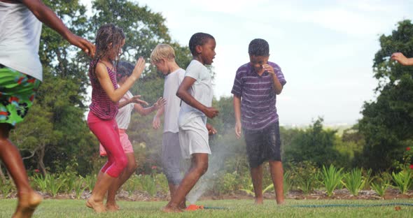 Kids playing with garden sprinkler