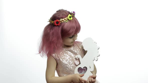 Girl Holds Holds Wooden Photo Frame in the Form of Pregnant Woman. Mother's Day