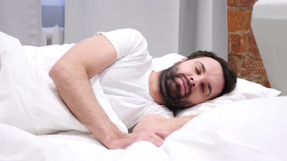 Beard Man Lying in Bed and Sleeping on Side Relaxing Resting