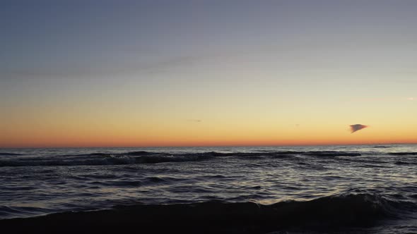 Majestic orange sunset above wavy ocean horizon, static view