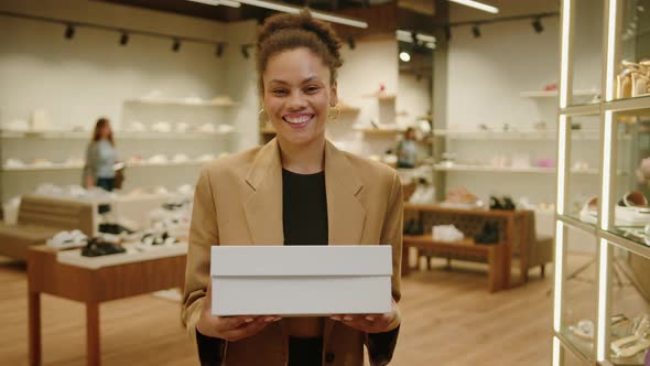 Happy Shopper with a Box of New Shoes in a Stylish Store