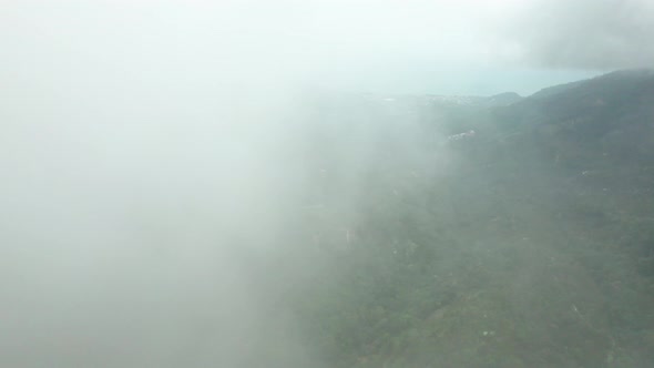 Fly thru a cloud revealing mountain forest natural landscape in Ko Samui, Thailand