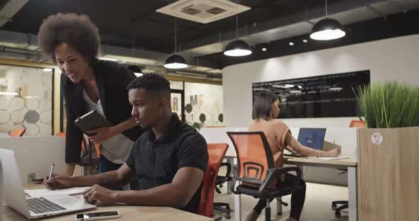 Black Boss Checking Employee in Office