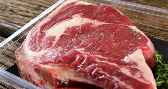 Rib chop and herbs in plastic container