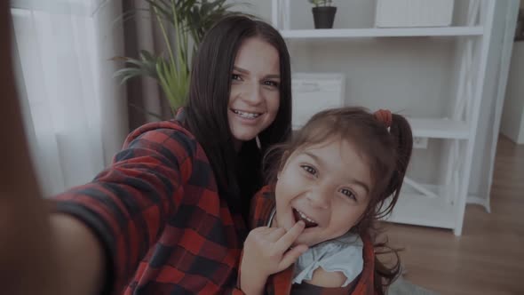 Happy Smiling Mother and Cute Preschool Daughter Laughing Taking Selfie on Smartphone, Cheerful Mom