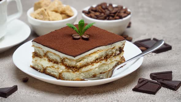 Portion of Traditional Italian Tiramisu dessert, cream or milk and cup of espresso coffee