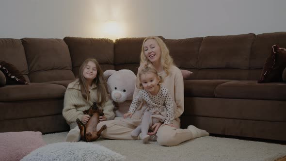 Mom and Daughters Playing with Dogs and Sitting By Couch Apartment Room Rbbro