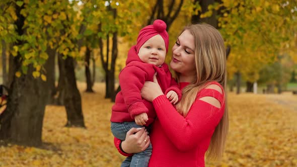 Young Mother and Child in Autumn Park