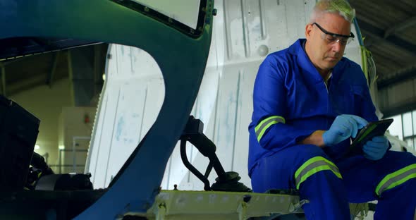 Engineer using digital tablet at aerospace hangar 4k