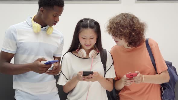 Young Teenage Friends Using Cell Phones in High School
